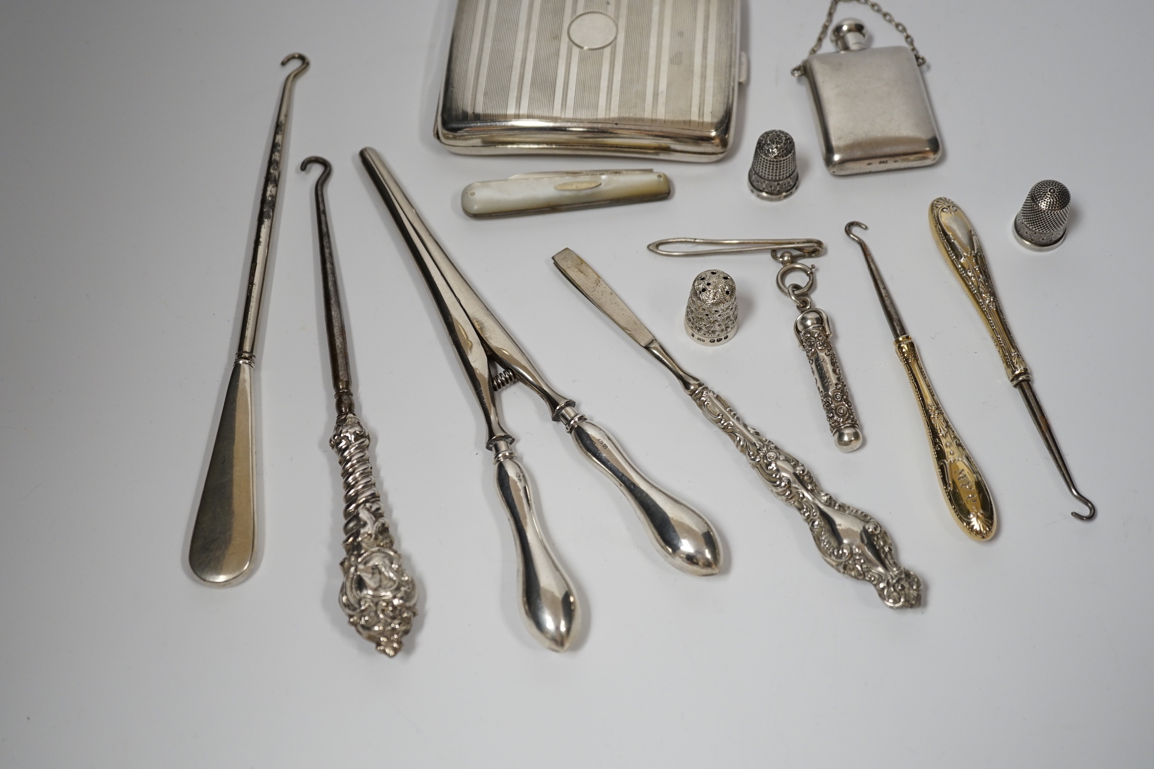 A George V silver cigarette case, Adie Bros. Birmingham, 1929, two silver and two sterling mounted button hooks and seven other items including propelling pencil in case, fruit knife and Italian 800 standard scent flask.